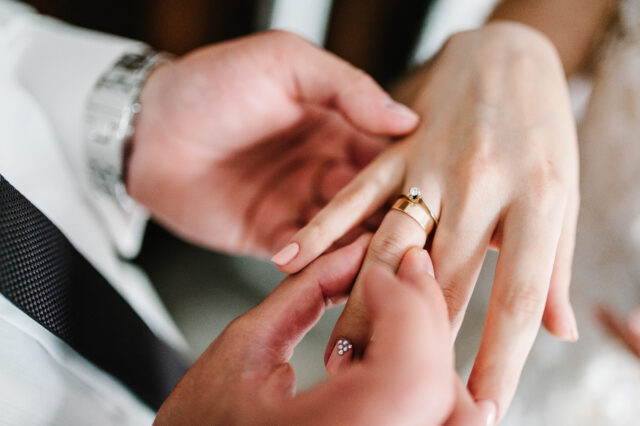 engagement ring band being place on a woman's hand; 10-year green card from marriage concept image